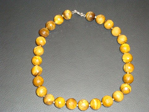 Necklace set with numerous faceted beads of Tiger Eye. 
L 44 cm. 
Pearl Dia. 15 mm. 
5000 m2 showroom.