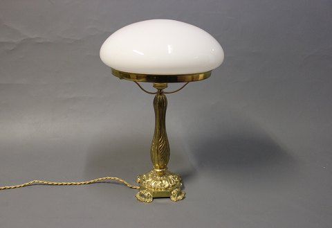 Bordlampe i messing med flot udsmykket fod og hvid glas kuppel. 
5000m2 udstilling.
