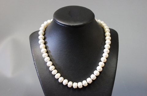 Necklace with semi round fresh water Pearls with White play and gilded Lock. 
5000m2 showroom.
