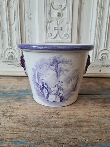 19th century English faience flower pot with lion heads as handle and manganese 
colored decoration