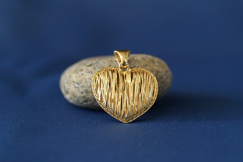 Smukt vedhæng i 14 karat guld, formet som hjertet med riflet mønster.
