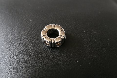 Charm til armbånd, fra  Pandora udført som cylender-formet med mønster med 
indlagt, klare hvide sten. 925 sterling sølv.