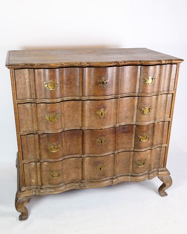 Baroque chest of drawers in oak with brass fittings decorated with wood carvings 
from the period around the 1780s.
Dimensions in cm: H:110 W:115 D:60
Great condition
