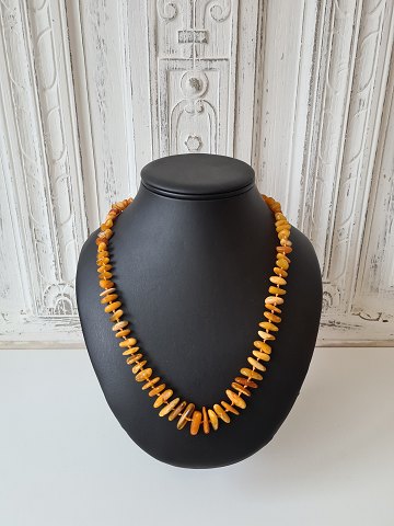 Long vintage necklace with polished amber pieces - length 64 cm.