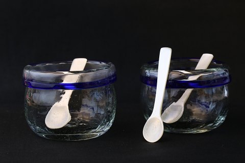 Små glasskåle med blåt bånd, og skeer af perlemor. Ideelt til salt og peber. 
