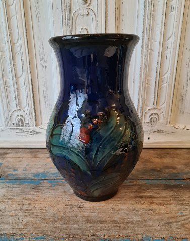 Danico stor midnatsblå vase dekoreret med grønne blade og røde bær 28 cm.