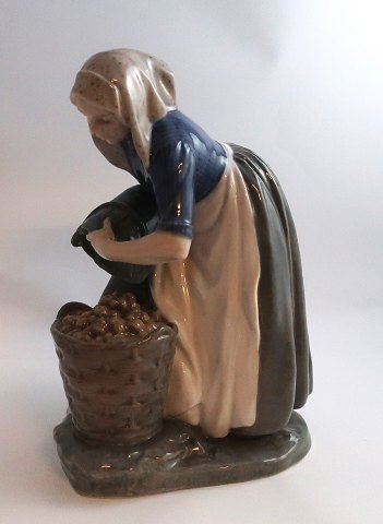 Royal Copenhagen. Porcelain figure. The potato collector. Model 1549. Height 
26.5 cm. (1 quality). Produced before 1923.