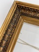 Old wooden gold frame with leaves and glass from the beginning of the 20th 
century