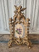 Large old picture frame decorated with an angel on top of the frame