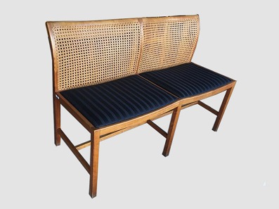 Bænk med stofbelagt sæde
Søren Horn
Mahogni. Ryg af flet. Sæde i sort stof. 
Længde: 110 cm. Højde: 78 cm. 
Fra 1960