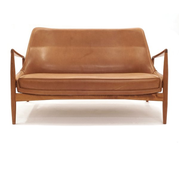 Ib Kofod-Larsen "The Seal" two seater sofa, teak and leather, by Brdr. Petersen, 
Denmark. Nice condition. L: 138cm